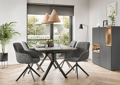 Modernes Esszimmer mit minimalistischem Design, das einen stilvollen dunklen Holztisch, graue gepolsterte Stühle, Pendelleuchten und eine elegante Anrichte umfasst.