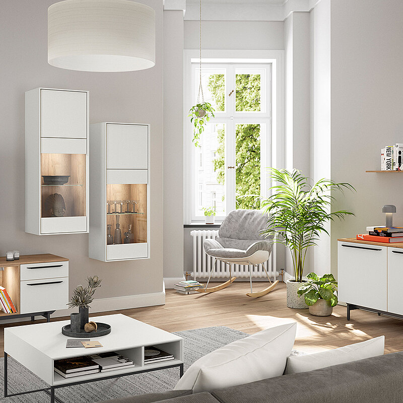 Zeitgemäßes Wohnzimmer mit eleganten Möbeln, grünen Pflanzen und natürlichem Licht, das eine ruhige und moderne Atmosphäre ausstrahlt.