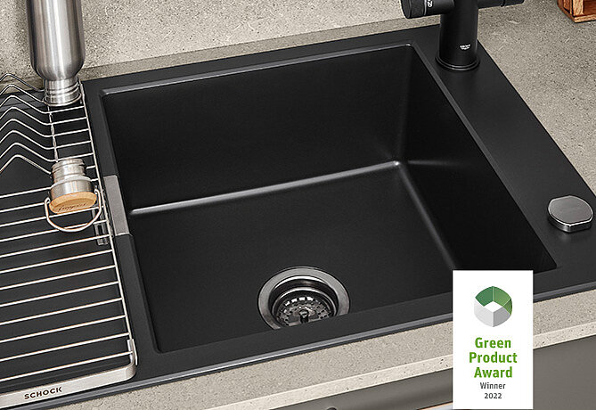Moderne schwarze Küchenspüle mit einem eckigen Design, zusammen mit passendem Wasserhahn auf einer Stein-Arbeitsplatte, Gewinner des Green Product Award 2022.