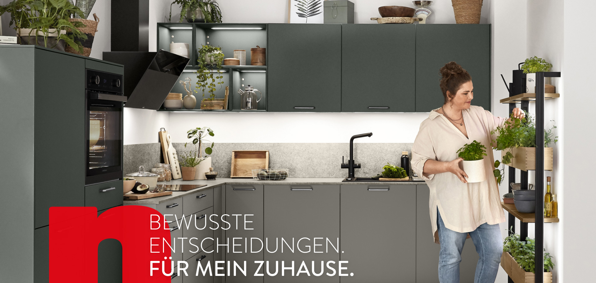 Moderne Küchenszene mit einer Frau, die Kräuter organisiert, zeigt elegante Geräte und Schränke mit der Botschaft "Bewusste Entscheidungen für mein Zuhause".