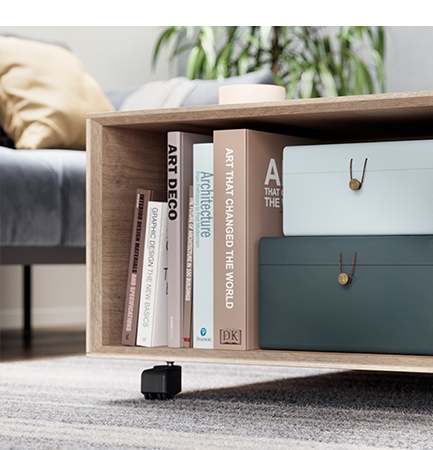 Moderne Holzbücherregal mit einer Auswahl an Büchern über Kunst und Design neben stilvollen Aufbewahrungsboxen in einem gemütlichen Wohnzimmer.