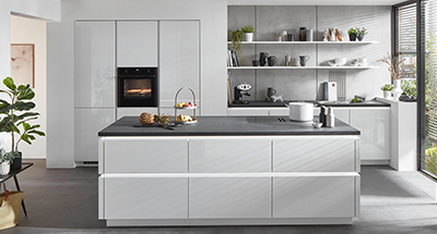 Moderne Küche mit weißen Schränken, Edelstahlgeräten, schwebenden Regalen und einem minimalistischen Design.